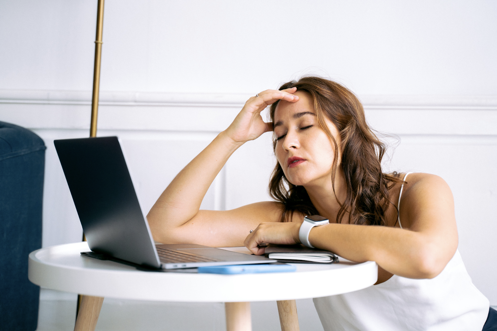 A woman holds her head as she experiences headache while looking into digital screen for long hours.