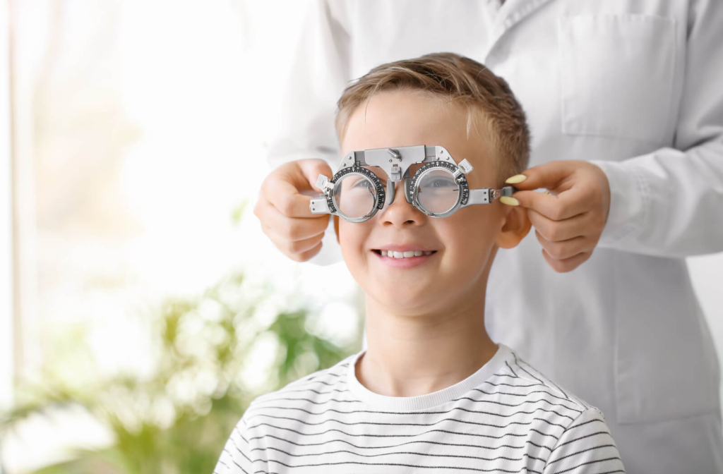 A boy is wearing an optical trial frame, getting an eyeglass prescription for astigmatism.