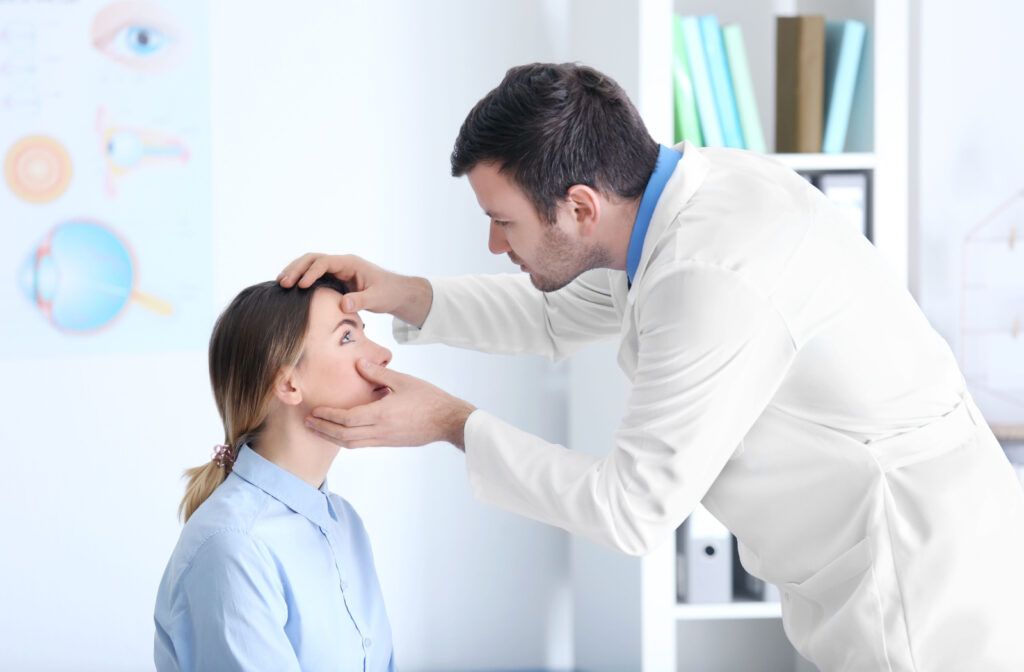 A male optometrist checking a woman's eye to check for pink eye or symptoms of stye.
